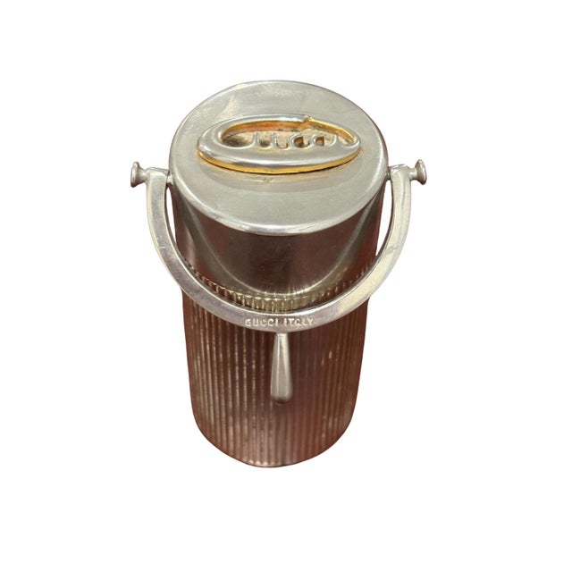 A striking vintage Gucci Italian table lighter featuring a cylindrical ribbed metal body, hinged lid and sculptural swing...