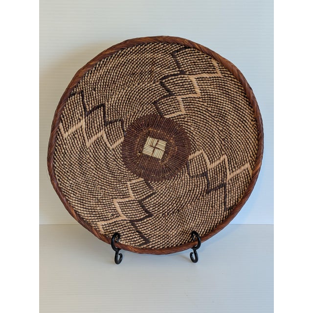A wonderful 1980s hand woven Binga basket from Zimbabwe. Woven with native grasses and a bark dyed palm rim rolled in a...