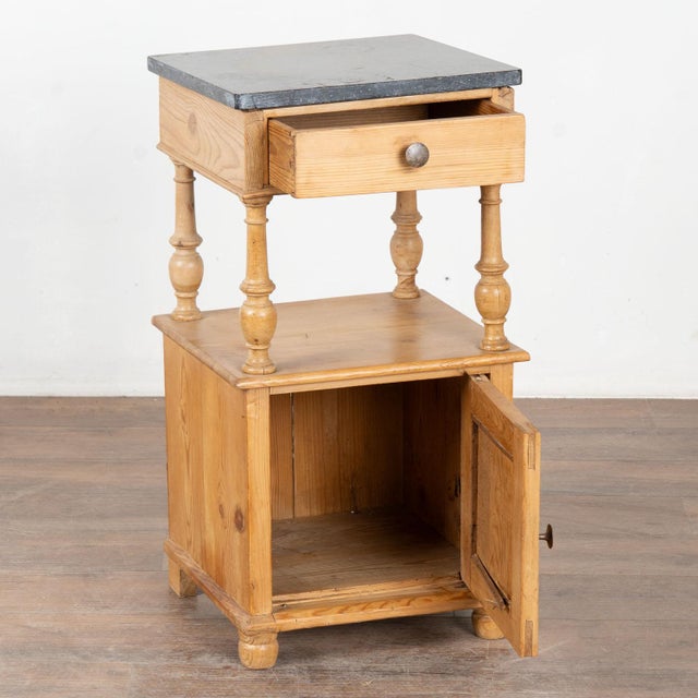 Early 20th century small nightstand, crafted in pine with an old marble top. This cabinet features one small drawer above...