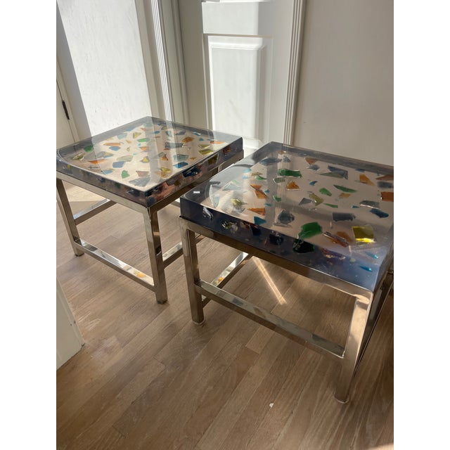 Pair of side tables sourced from the French Flea Market. Bases are chrome and tops are resin with colored shapes. Truly...