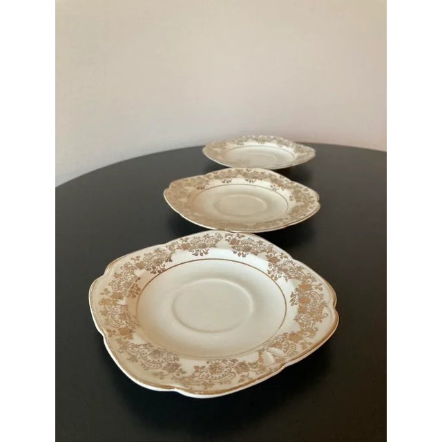 A set of three (3) tan and 22K gold gilt porcelain cocktail drinks coasters, circa early 20th century. A set with...