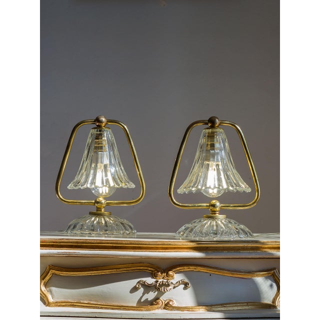 A pair of vintage Barovier & Toso table lamps, made in Murano in the 1950s. The brass structure forms a softly curved...