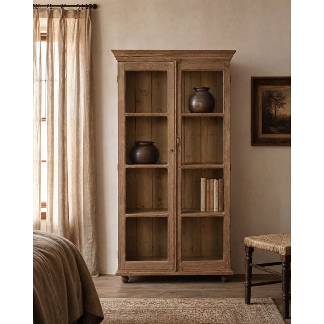 Four shelves, entirely visible. A ball-foot base that lifts the piece just enough to breathe. This antique Indian teak...