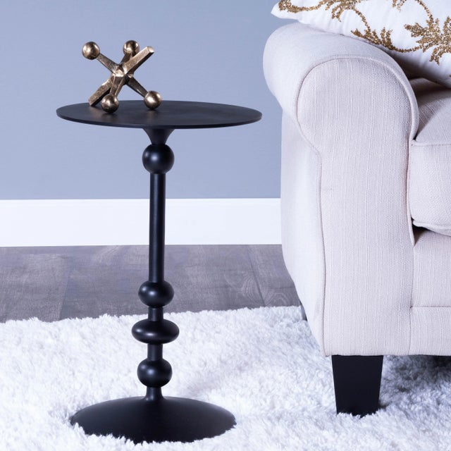 Smooth rounded curves seemingly emanate from the base of this round iron End Table. Coupled with a distressed matte black...