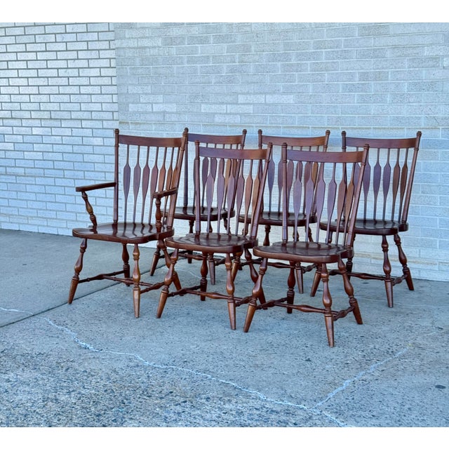 Solid hardwood construction by Harden Furniture. Set of six dining chairs with shaped spindle backs and turned legs. Warm...