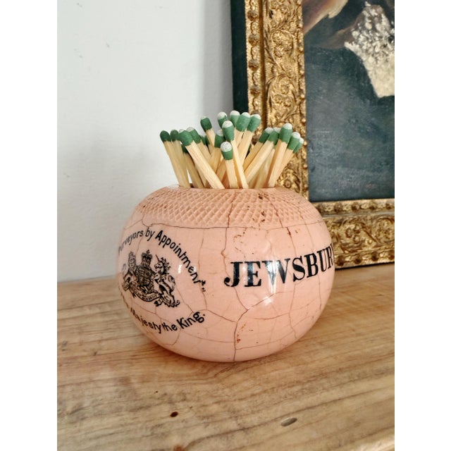 An antique English stoneware match strike in a lovely pale, earthy pink shade, made to be used in a pub to advertise...