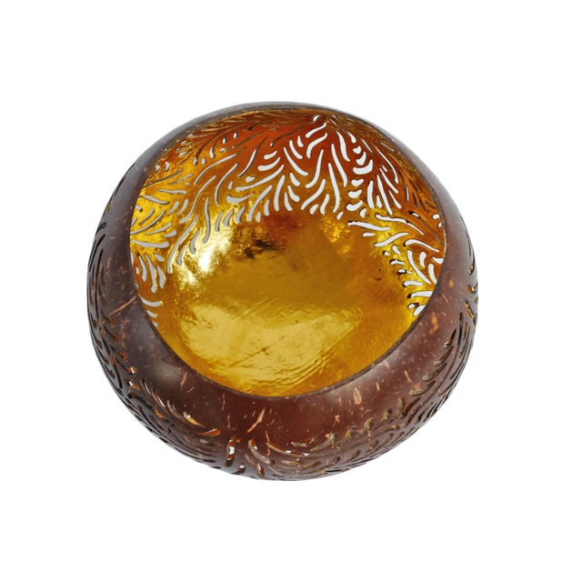Beautiful hand carved coconut tea light holder with warm gold leaf finish inside. Creates beautiful light patterns on...