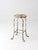 An early 20th century twisted iron garden stool or plant stand featuring looping feet and a weathered wood veneer inset...