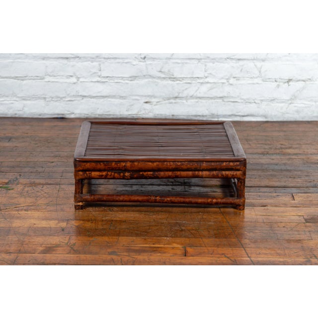 A Chinese Qing Dynasty bamboo low coffee table from the 19th century, with slatted top. Created in China during the Qing...