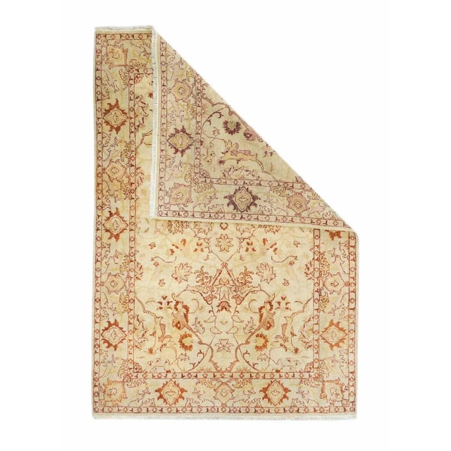 This northern Indian, well-woven piece shows an ecru field centred by an open four palmette indented cruciform, escutcheon...