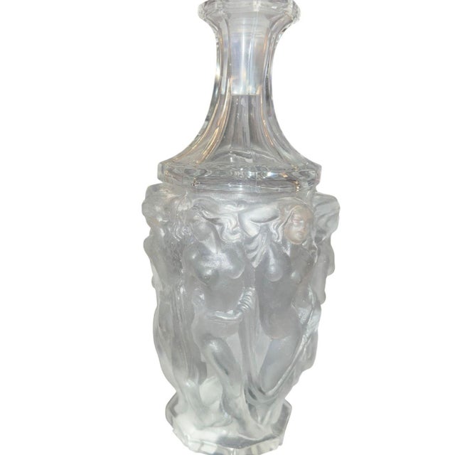 This elegant Lalique drinking set includes a sculptural frosted glass decanter accompanied by three matching shot glasses,...