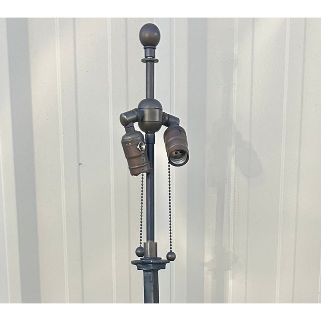 A beautifully crafted mid-century floor lamp featuring a sculptural hand-forged iron frame with painted bronze over gilt...