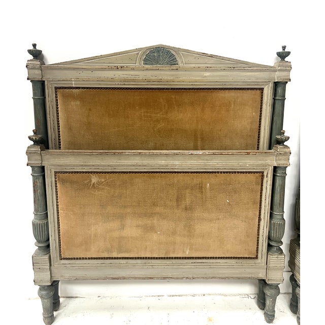 Pair of Louis Directoire style beds in patinated beechwood Frame with turned columns decorated with tops Two fluted rails...