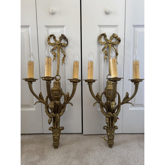 Offering for sale this stunning pair of Louis XVI-style, solid heavy brass, 3-arm wall sconces with the following fine...