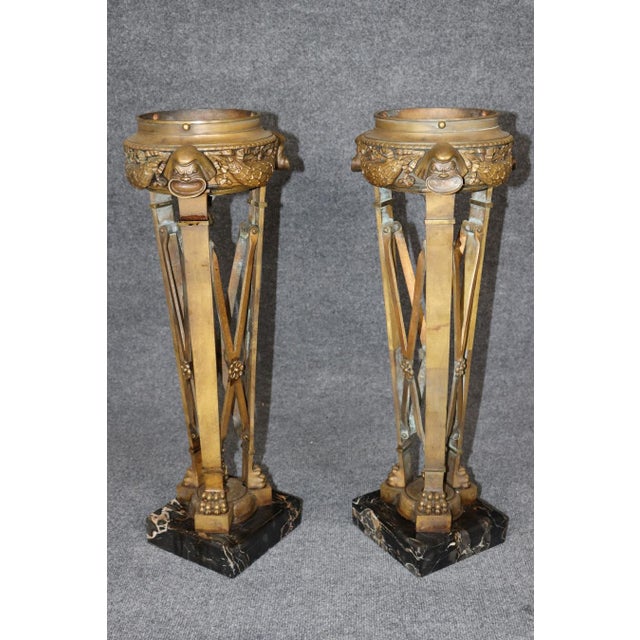 An extraordinary and highly unusual pair of antique French neoclassical gilt bronze urns, distinguished by their...