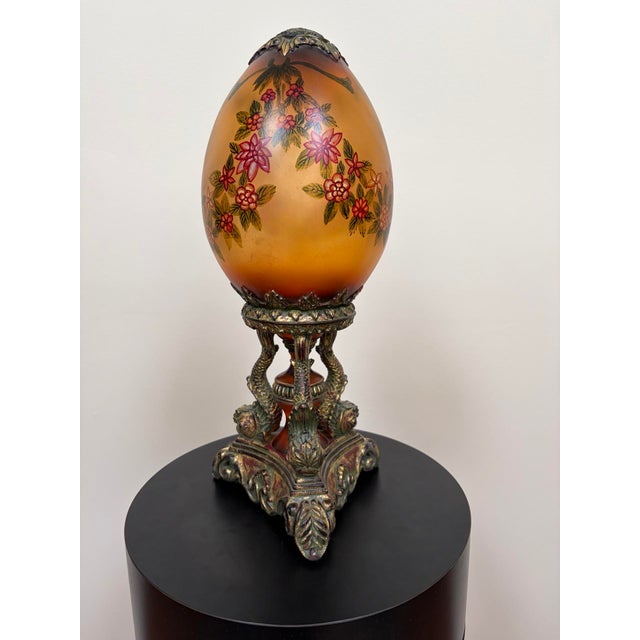 Vintage Hollywood Regency hand-painted porcelain “egg” sculpture with floral garlands on an amber-gold ground, mounted to...