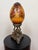 Vintage Hollywood Regency hand-painted porcelain “egg” sculpture with floral garlands on an amber-gold ground, mounted to...