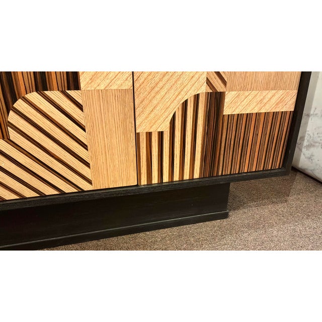 Original retail $3740, stylish Currey & Company Modern Wood Memphis Cabiet, oak Mindi, mahogany, and Macassar Ebony...