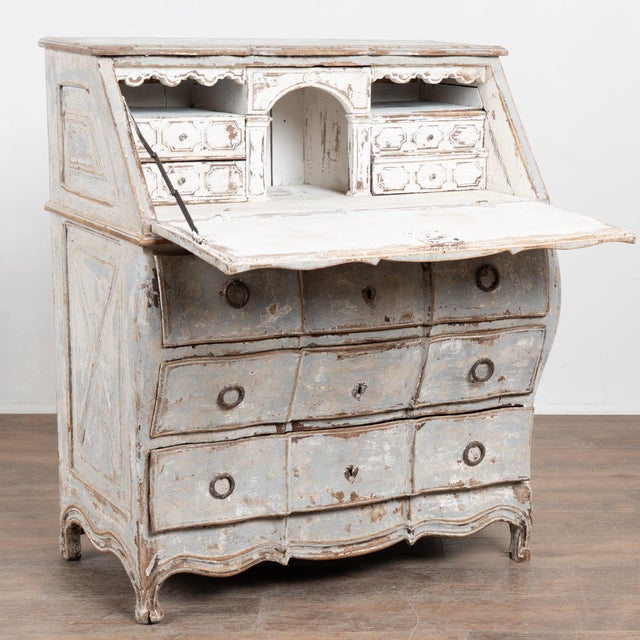 Swedish oak ladies’ writing desk or secretary featuring a Bombay-curved lower chest with three drawers. The side panels...