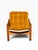 A chunky, sun-warmed Danish modern lounge chair built from solid pine, with thick round post legs and broad flat arm rails...