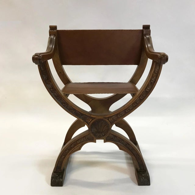 Mid-20th century, craftsman, Campaign or prayer chair features a carved cherry frame with newly upholstered luggage tan...