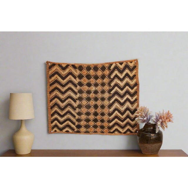 A captivating masterpiece of African textile art, this vintage Kuba cloth panel is a testament to the unparalleled...