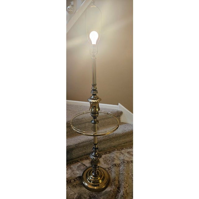 Hollywood regency floor lamp with heavy brass base and glass tray table. Beautiful urn detail above and below the table.
