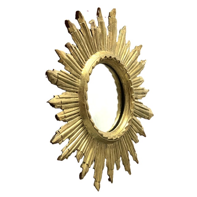 An elegant sunburst mirror in carved and gilded wood, made around 1950. Retaining its original gilding, it boasts a superb...