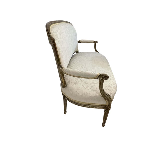 A classic 19th-century Louis XVI giltwood canape or settee upholstered in a cream-on-cream embroidered crewel type fabric....