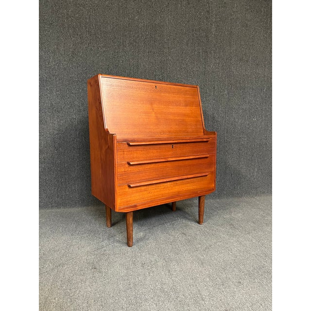 Here is a beautiful Scandinavian modern secretary desk in teak wood. This piece features a set of 2 small drawers, cubby,...