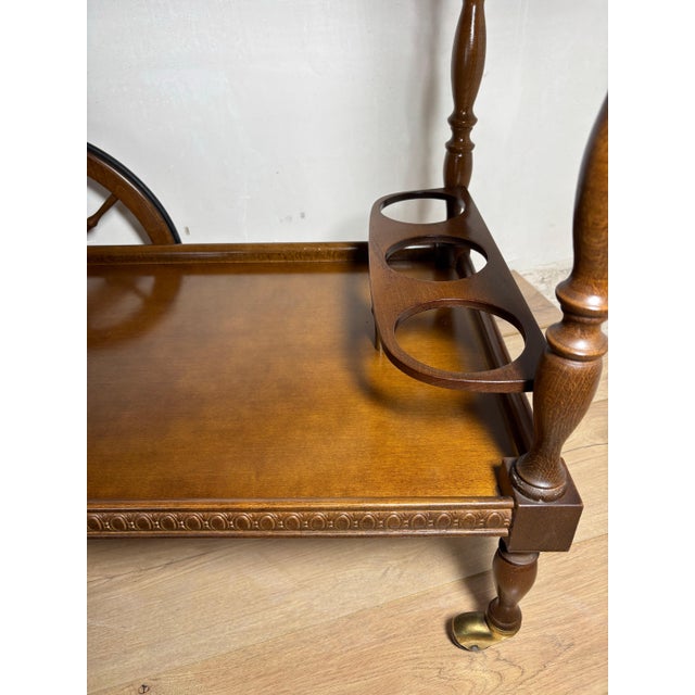 Elegant Spanish bar cart crafted in solid wood, featuring a classic two-tier design with finely turned legs and decorative...