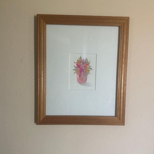 This painting features a soft, loose bouquet of colorful flowers in a pink vase. The impressionistic style and bright hues...