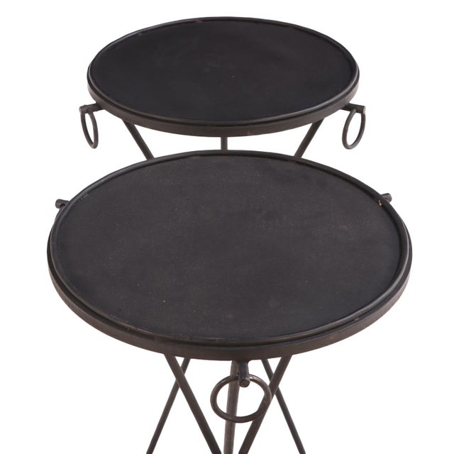 Each table features a painted iron top accented with three hanging rings from the apron. The tripartite iron base creates...