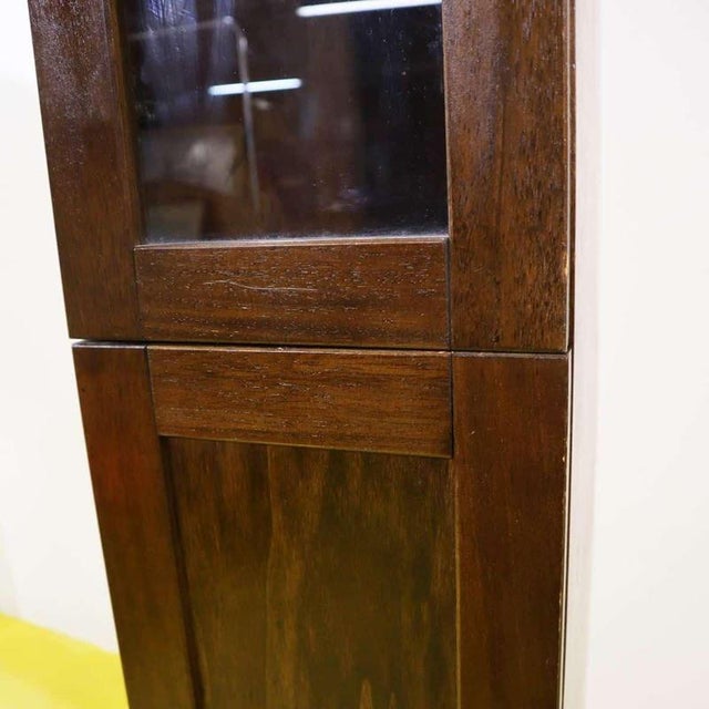 Wooden column cabinet featuring a glass door and ceramic knobs.