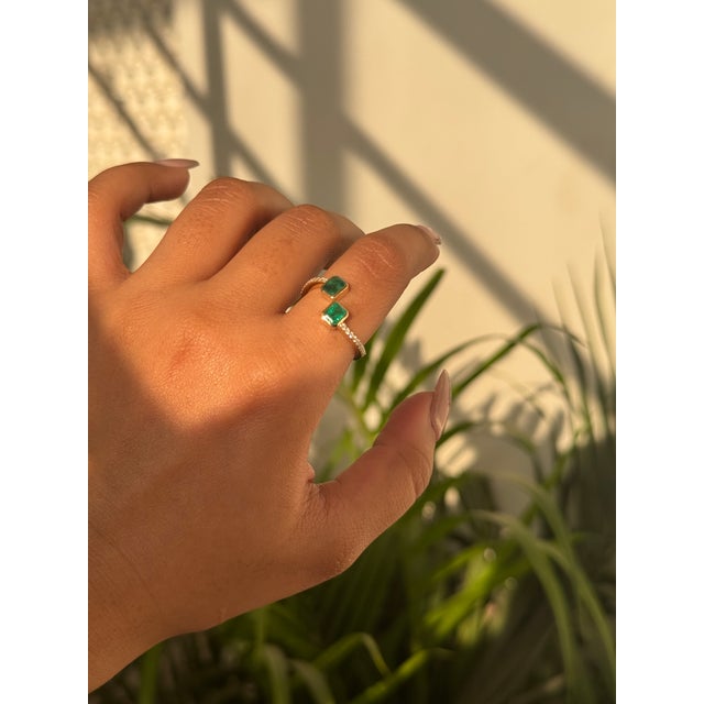 This open bypass ring features a 0.88 carat, set in 14k yellow gold. Individual emerald sizes around 5 x 4 mm,...