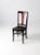 An early 20th-century Arts and Crafts-style side chair featuring a distinctive black fiddle back with a contrasting red...