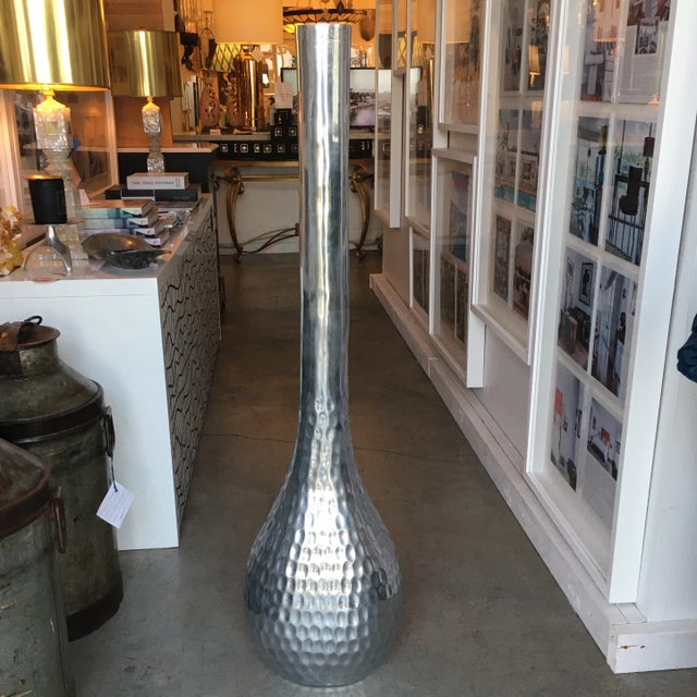 Tall silver metal vase/ vessel hand-hammered creating the textured design. This vessel is handmade and has unique...