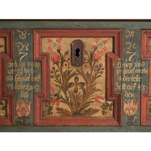 This antique painted marriage chest in pine is a Central European dowry chest with three floral panels and Gothic-lettered...