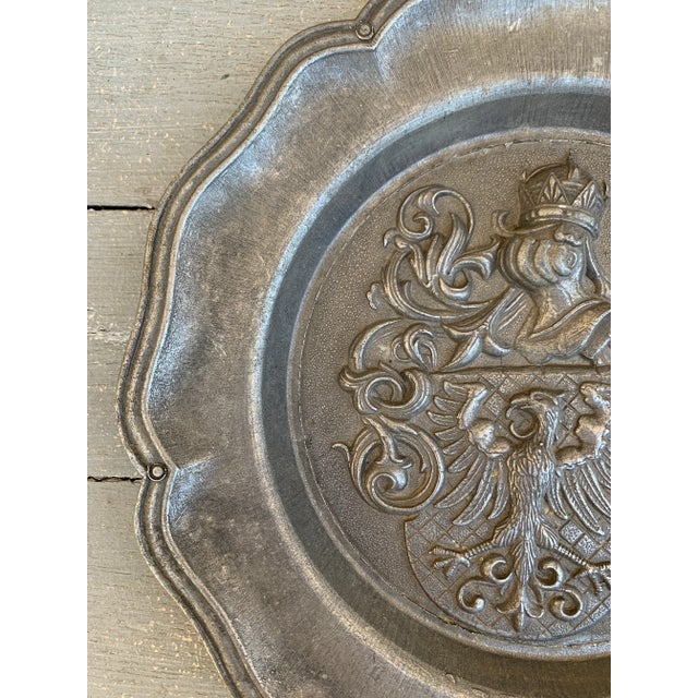 A beautiful pewter wall plate featuring a heraldic coat of arms with a knight and an eagle on a shield Germany, Mid-20th...