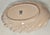 Gorgeous pink waves splash up around a scaled ivory edge on this late 20th century Lenox china piece.