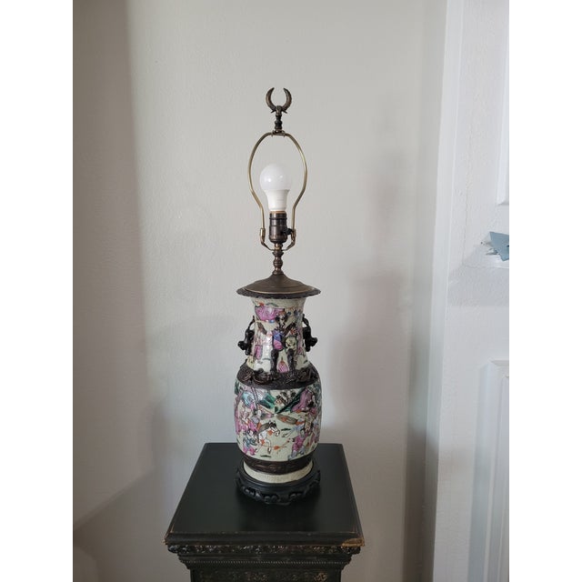 This beautifully detailed ceramic lamp features a classic Asian vase form decorated with hand‑painted figures, florals,...