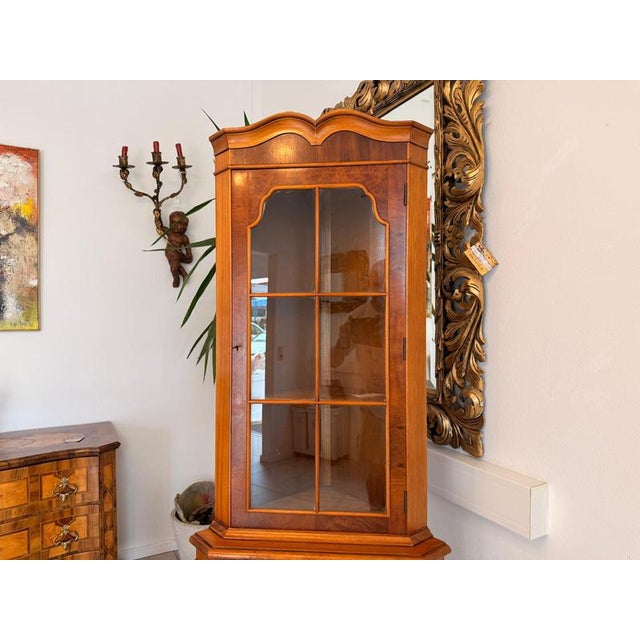 Corner glass display cabinet in colonial style. Dimensions: Height x Width x Depth 187 cm x Leg 46 cm. For sale is a...