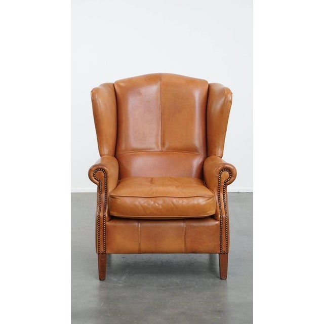 Offered this unique and comfortable ear armchair made of cowhide leather finished with decorative nails and beautiful...