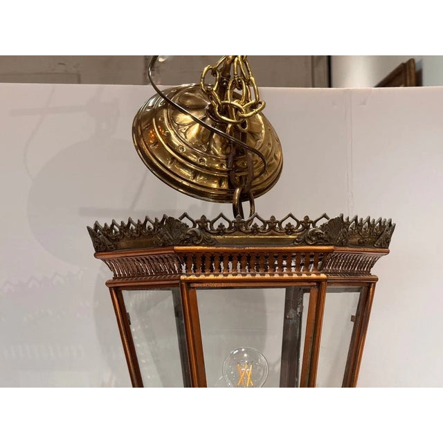 An Italian brass and copper lantern with beveled glass panels, surmounted by a pierced foliate crown gallery. Retains its...