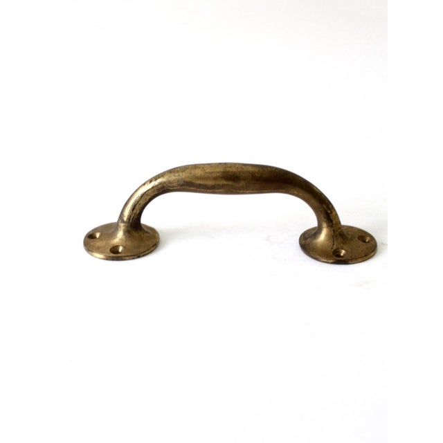 The elegant vintage brass door handle features clean lines, a rich, aged finish, and a rustic appeal.