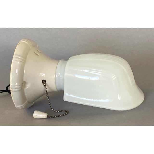 The glass shade clips into place by means of a metal spring. It can be (gently) swiveled in any direction. The pull chain...