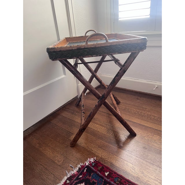 This piece is a vintage British Colonial style butler's tray table. It features a removable wooden serving tray lined with...