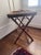 This piece is a vintage British Colonial style butler's tray table. It features a removable wooden serving tray lined with...