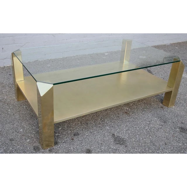 Pair of custom rectangular brass coffee tables with glass top and brass shelf. Height of brass shelf: 6.25”.