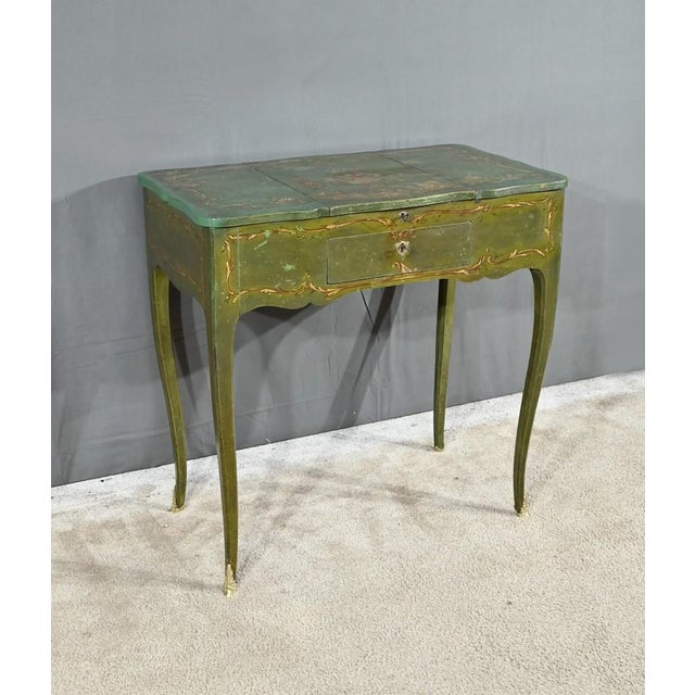 This small dressing table in fern green painted oak opens at the waist with a drawer with original lock with coat of arms...